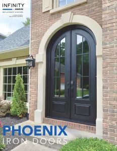 Elegant black arched iron double doors set in a brick house entryway with glass panels and decorative molding.