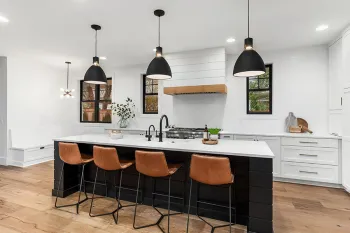 a kitchen with a bar stool and a white counter top