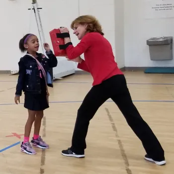 a woman holding a bow and arrow next to a girl holding a bow