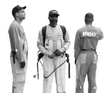 Three workers in uniforms and caps, one holding spray equipment, standing isolated on white background.