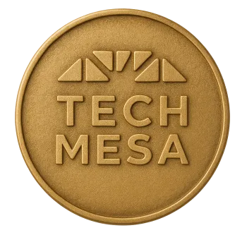 Gold coin embossed with Tech Mesa logo featuring stylized sun rays above text.