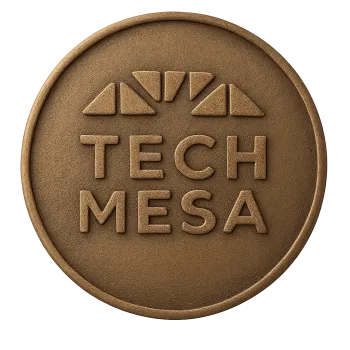 Round bronze emblem with embossed Tech Mesa text and triangular shapes above the letters.