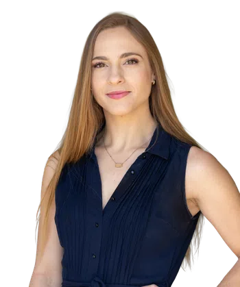 Confident young woman with long hair wearing a navy blue sleeveless dress, gold jewelry, and a slight smile