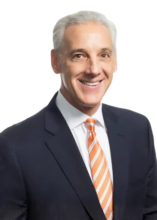 Smiling middle-aged man with gray hair in a dark suit and orange striped tie on white background