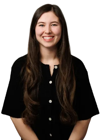 Smiling young woman with long brown hair wearing a black button-up top against a plain background