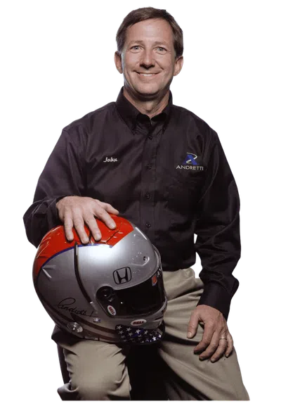 Man in Andretti shirt holding a racing helmet with Honda logo and American flag design, smiling