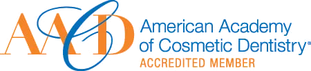 Logo of American Academy of Cosmetic Dentistry Accredited Member with blue and orange text and a stylized orbit design