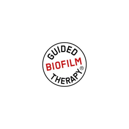 Logo displaying the phrase Guided Biofilm Therapy in black and red text inside a white circle on black background