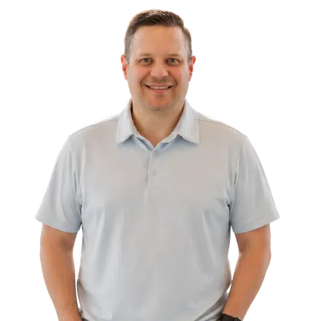 Smiling man wearing a light gray polo shirt and a black wristwatch standing against a white background