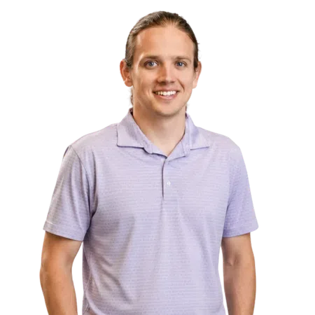 Smiling young man with brown hair in a lavender polo shirt standing against a transparent background