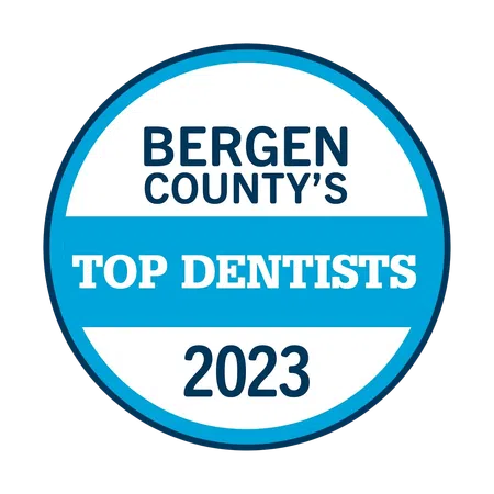 Bergen County's Top Dentists 2023 badge with blue and white circular design.