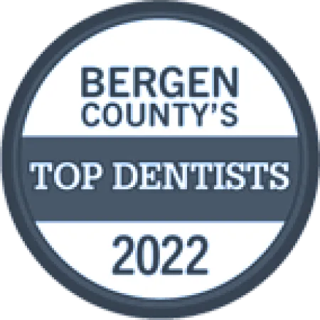 Badge reading Bergen County's Top Dentists 2022 in blue and white circular design