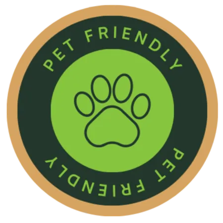 Round pet friendly badge with green paw print icon and text on dark and tan circular background