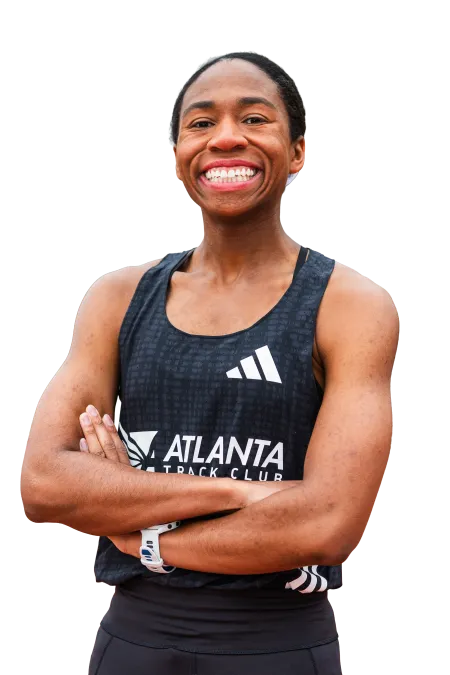 Smiling athlete in Atlanta Track Club uniform with arms crossed, showing confidence and fitness.