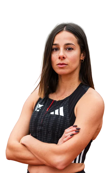 Confident athletic woman with crossed arms wearing a black sleeveless sports top with logos