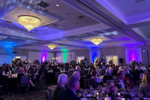 a large group of people sitting at tables in a room with lights