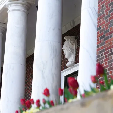 a white building with pillars and flowers