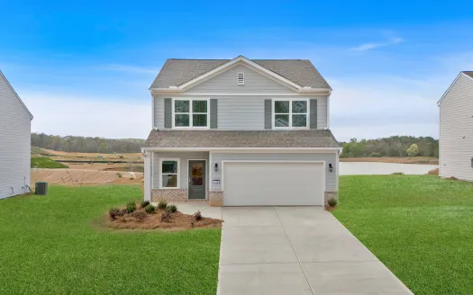 Stylish two-story house with a manicured lawn and clear blue sky background.