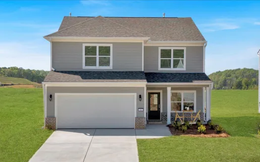 Modern two-story house with landscaped front yard and clear blue sky backdrop.