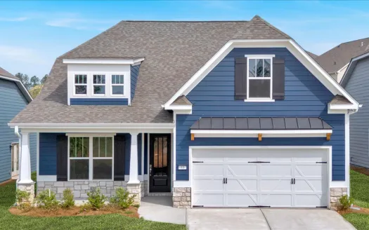 Modern blue house with white trim, stone accents, front porch, and double garage under clear blue sky