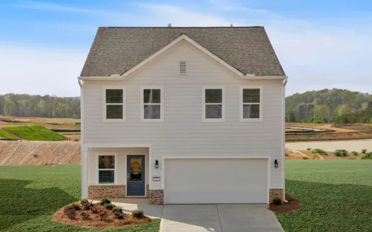 Modern two-story white house with gray roof, garage, and landscaped front yard under blue sky.
