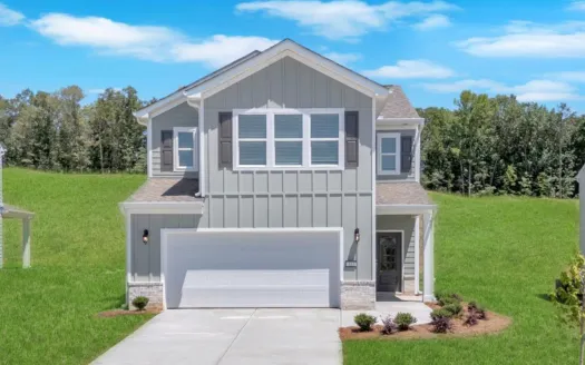 Modern two-story gray house with large garage, front porch, and landscaped yard on sunny day
