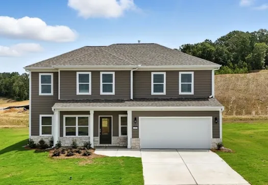 Modern two-story gray house with white trim, large driveway, and well-maintained green lawn under a partly cloudy sky.