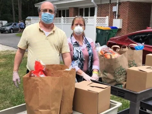 a man and a woman with boxes on a cart