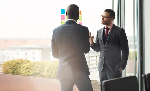 a man in a suit talking to another man in a suit