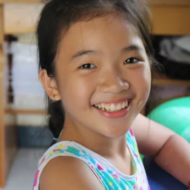 a little girl smiling at the camera