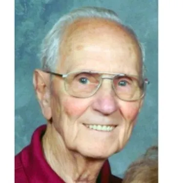 a person wearing glasses and smiling at the camera