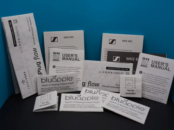 Various product manuals and packaging for bluapple and MKE 600 Plug flow occlusion system against blue background.