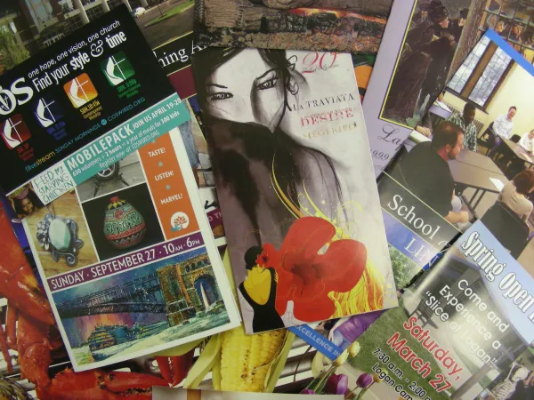 Collection of colorful promotional flyers and posters featuring events, art, and community activities.