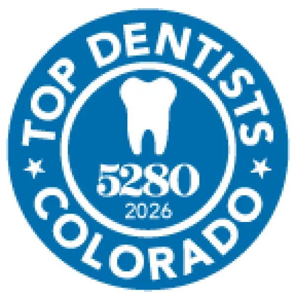 Blue circular badge with white tooth icon, text Top Dentists Colorado, number 5280, and year 2026.