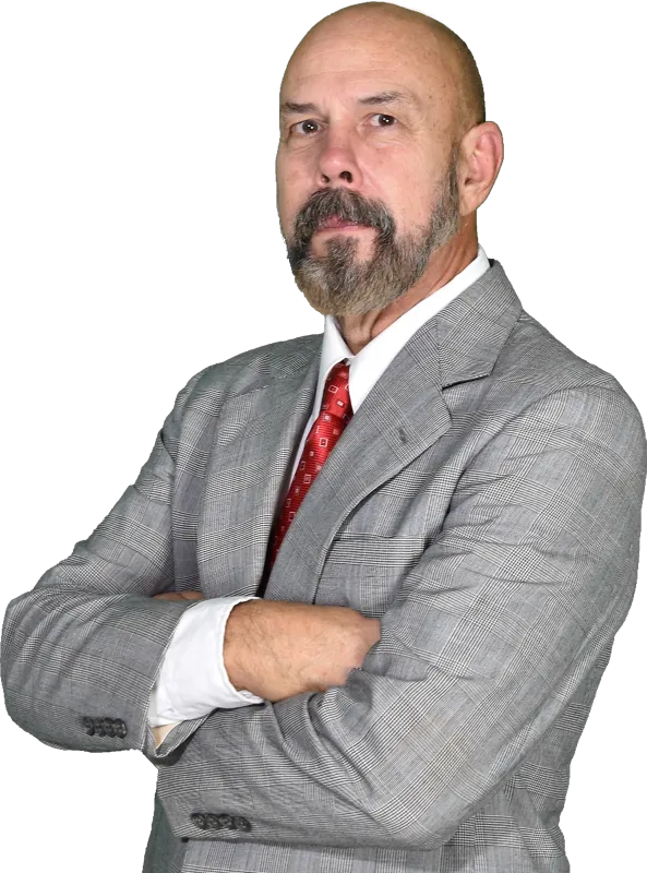 Confident middle-aged man with beard in gray checkered suit and red tie posing with arms crossed