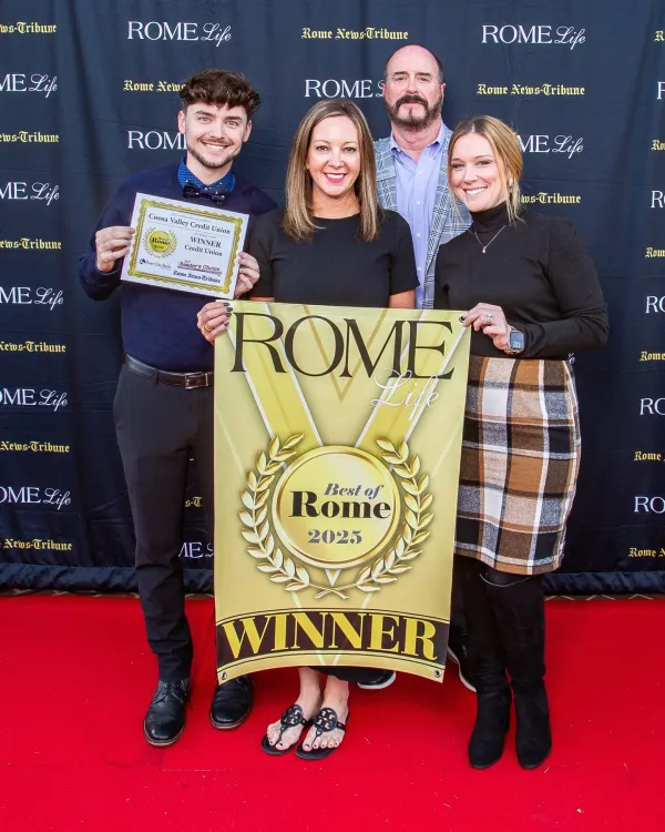 Four people holding Best of Rome 2025 winner banners on red carpet at Rome Life event.