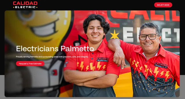 Two smiling electricians in red and black Calidad Electric shirts standing in front of a colorful branded mural.