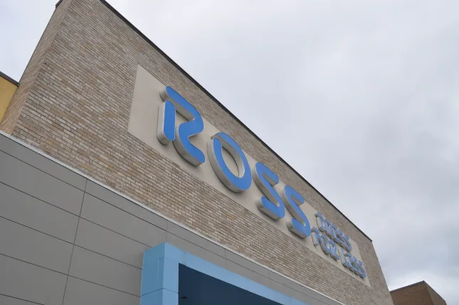 Blue Ross Dress for Less sign on beige brick and gray modern building under overcast sky.
