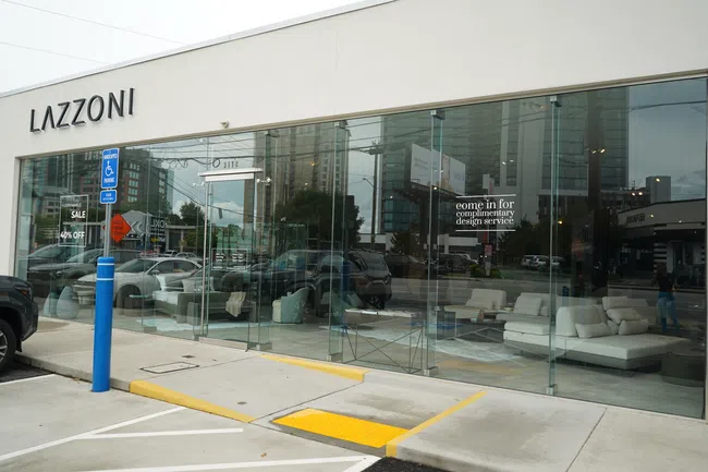 Modern furniture store Lazzoni with glass facade displaying white sofas and interior design services offer