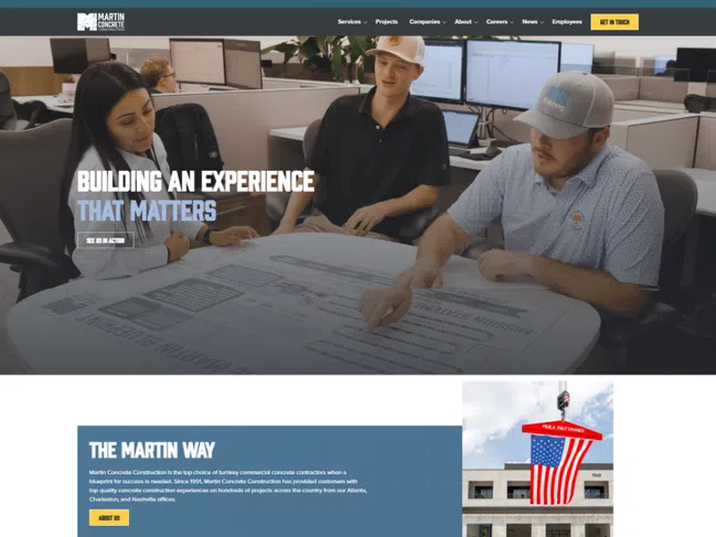 Team reviewing blueprints at Martin Concrete office showcasing construction planning and collaboration.