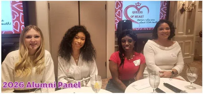 Four women sitting at a table during the 2026 Alumni Panel with Queens of Heart logo in background