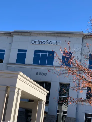 Modern medical office exterior featuring the OrthoSouth sign against a clear blue sky.