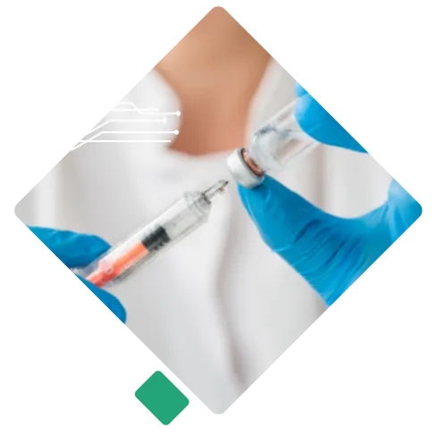 Close-up of a healthcare worker wearing blue gloves preparing a vaccine syringe from a vial.