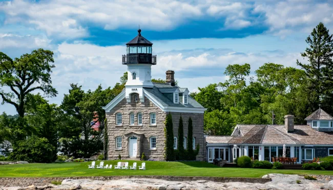 a large house with a light house with Mission Point Light in the background