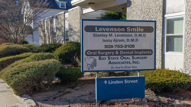 Sign for Levenson Smile dental surgery and implants at 9 Linden Street with phone number and doctors' names.