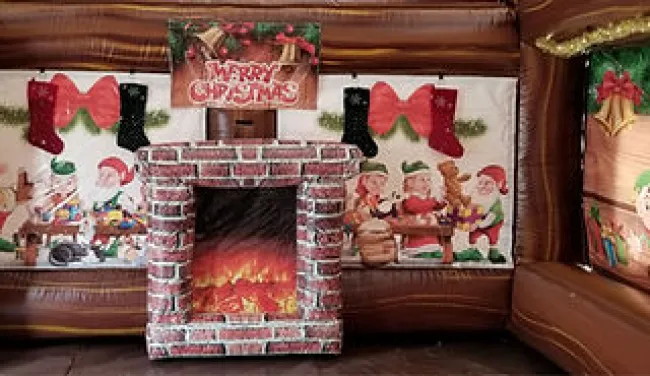 Inflatable brick fireplace with festive Christmas decorations and elf illustrations on backdrop walls