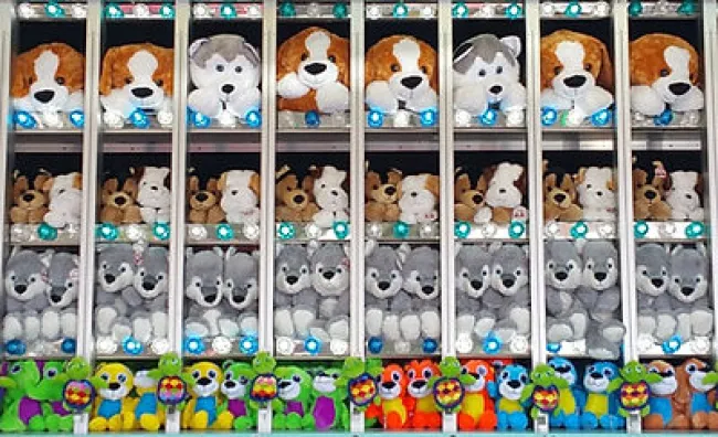 Rows of colorful and large stuffed animal prizes displayed at a carnival game booth.