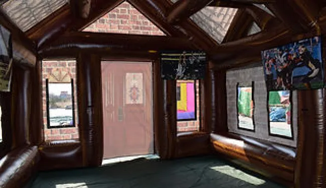 Interior view of a brown inflatable structure with windows and a glass ceiling letting in natural light.