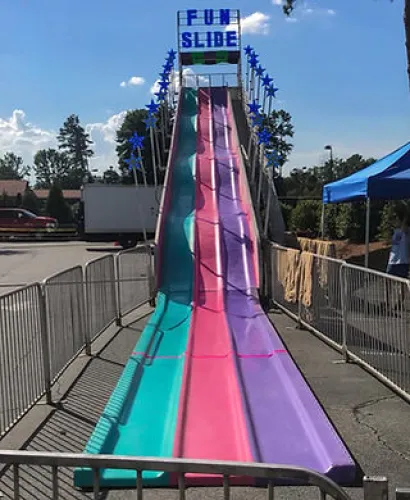 Colorful three-lane outdoor fun slide with blue star decorations under a sunny sky