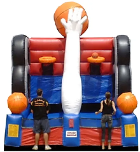 Two people playing on an inflatable basketball hoop game with large orange basketballs and a giant hand design.